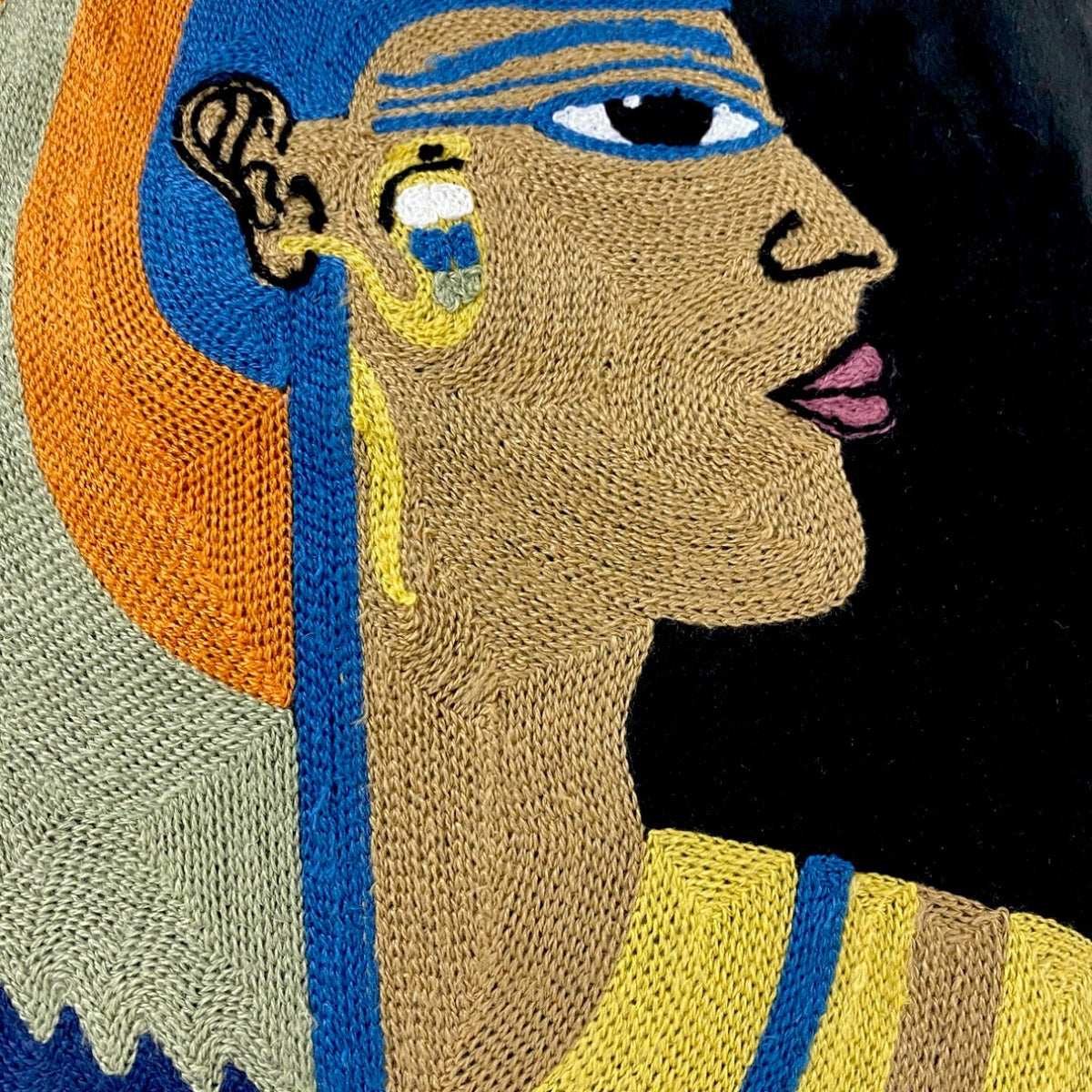Close-up of the chain-stitch embroidery on the Cleopatra velvet cushion cover: face, earring and collar