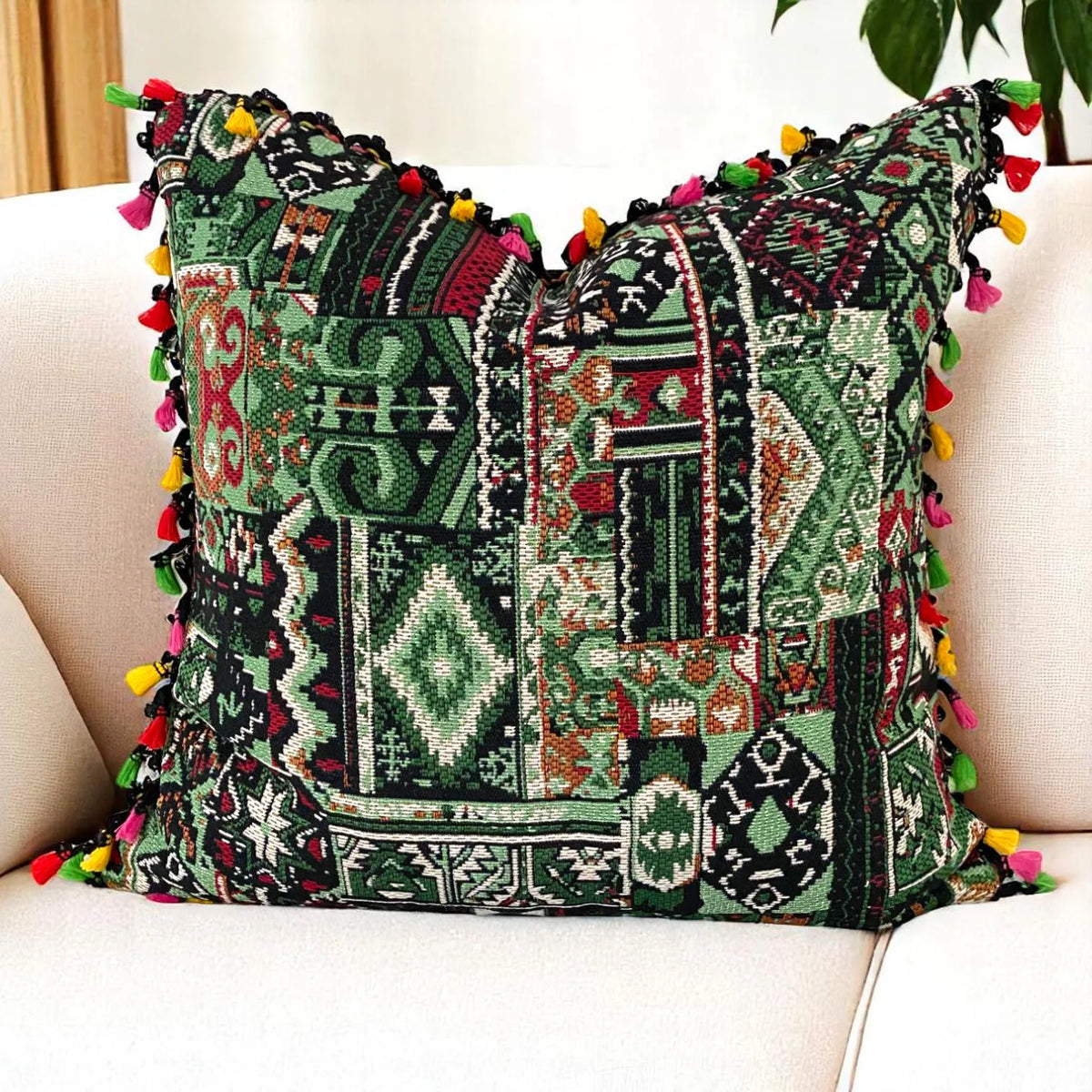 Boho kilim scatter cushion cover in deep green, black and burgundy with tassels on a cream sofa