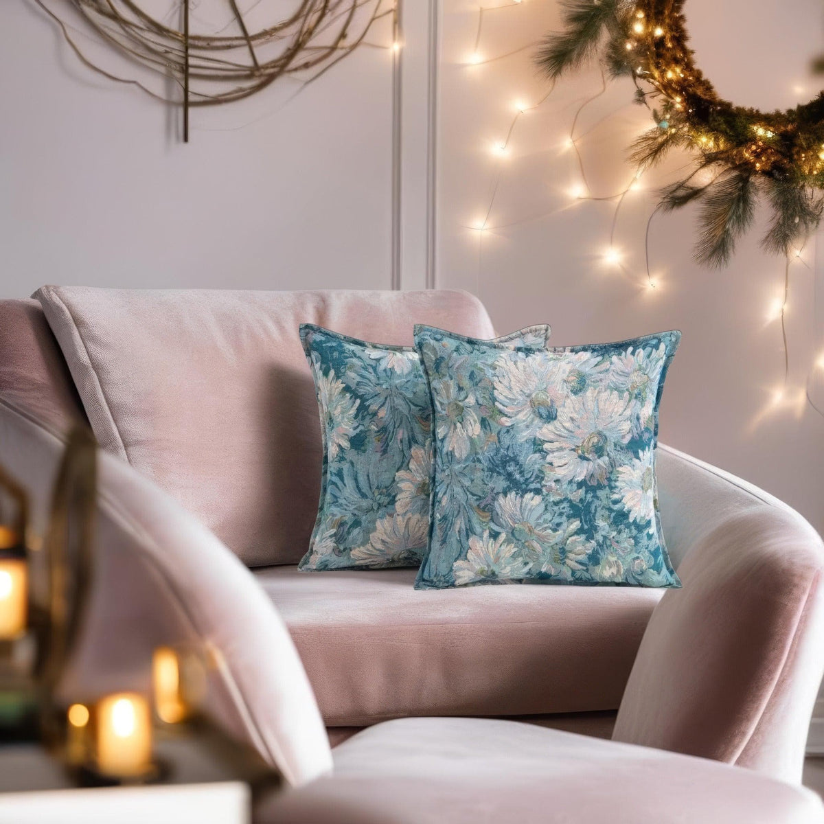 Teal tapestry cushion covers on a blush pink armchair with fairy lights and a festive wreath