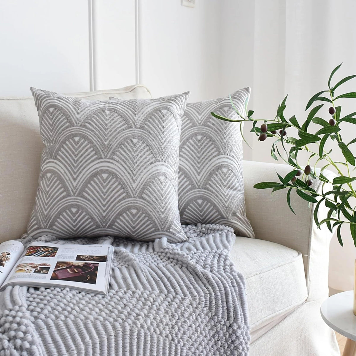 Embroidered cushion covers 50x50 cm, a set of 2 in grey and white Art Deco waves styled on a cream sofa