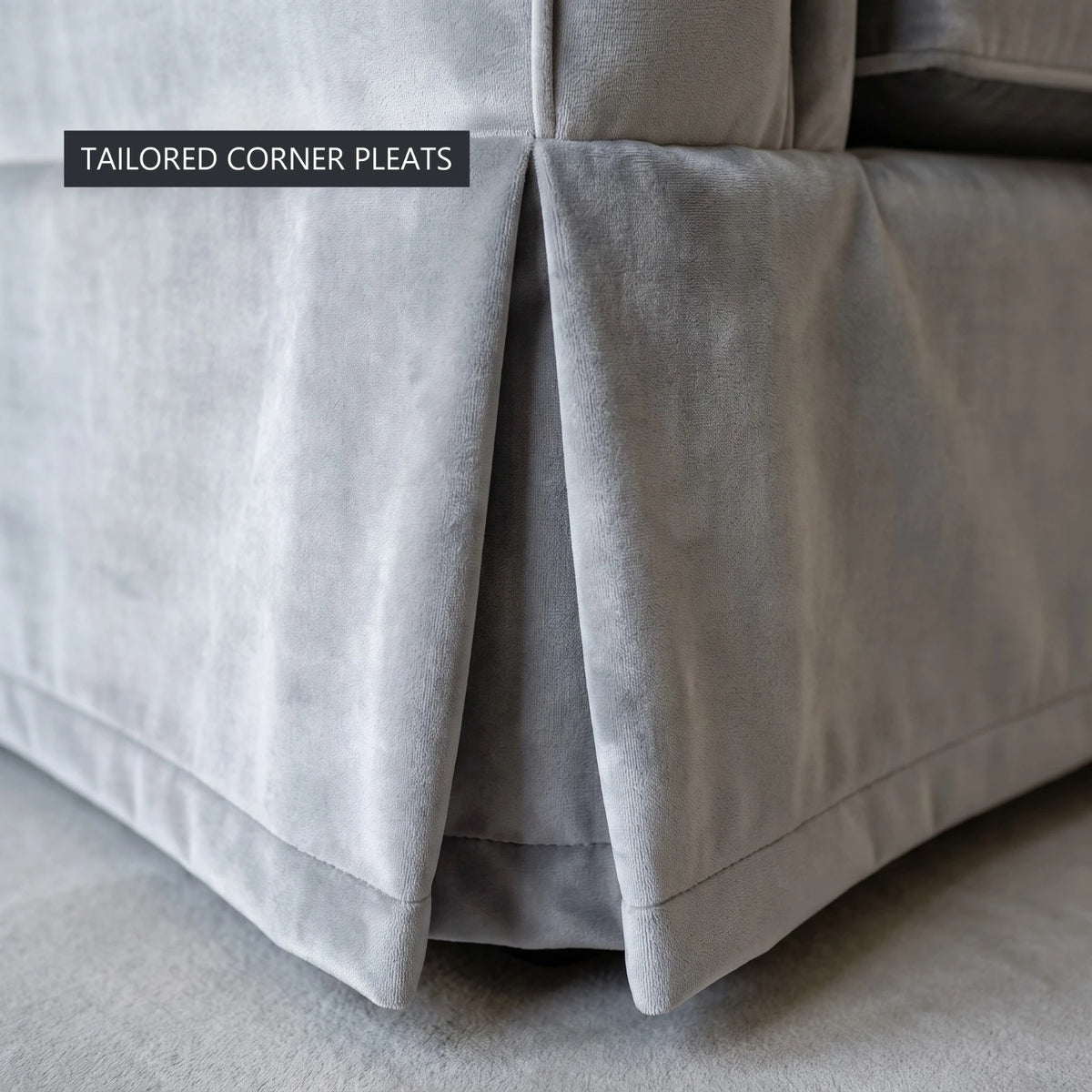 Close-up of the tailored corner pleats on the skirt of the grey velvet Ektorp sofa cover