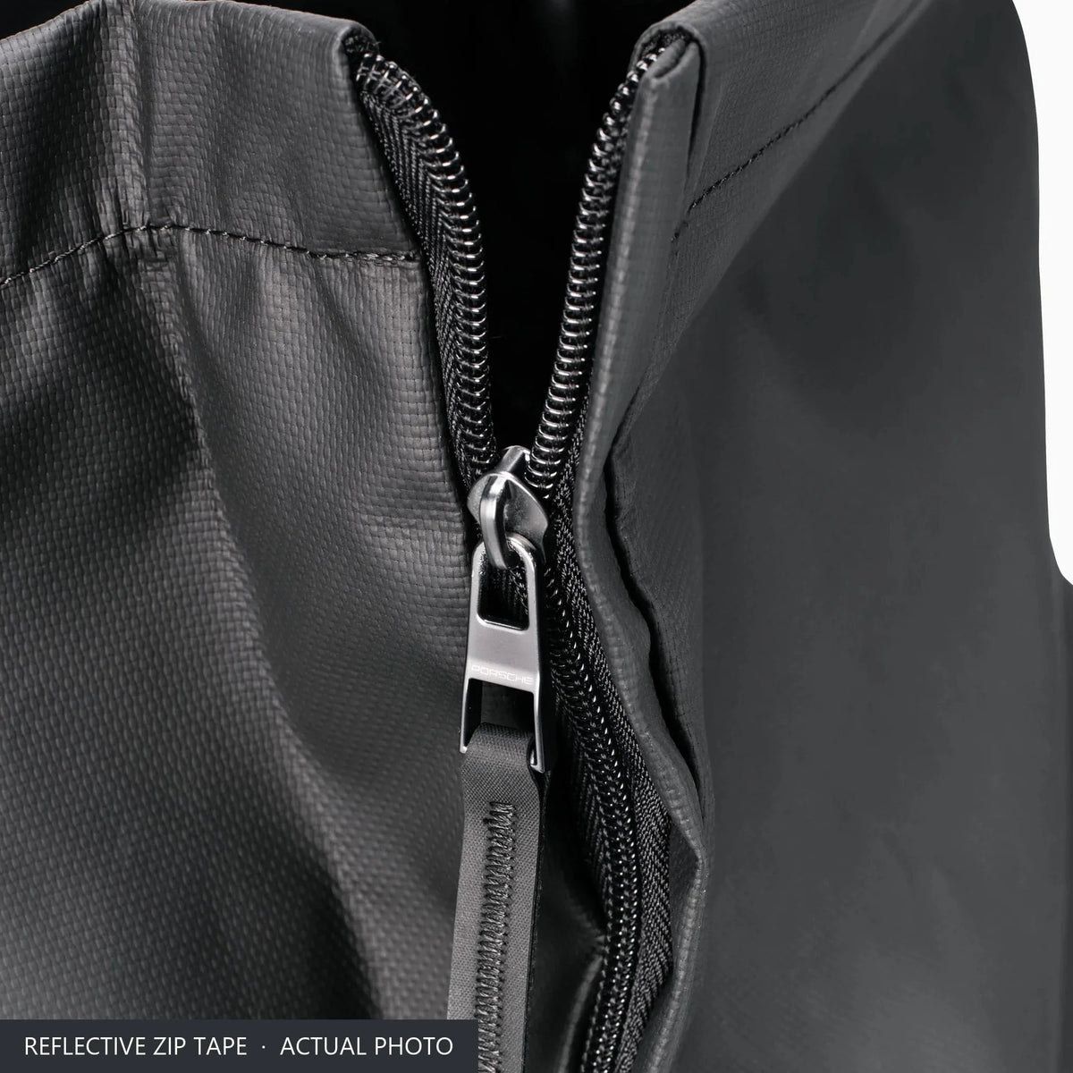 Reflective zip tape and metal zip puller on the front of the black Porsche 911 rucksack