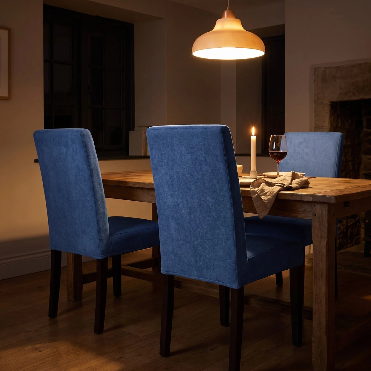 Denim blue dining chair covers on Bergmund chairs at a candlelit table