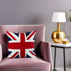 Union Jack throw pillow on a pink velvet armchair next to a gold table lamp