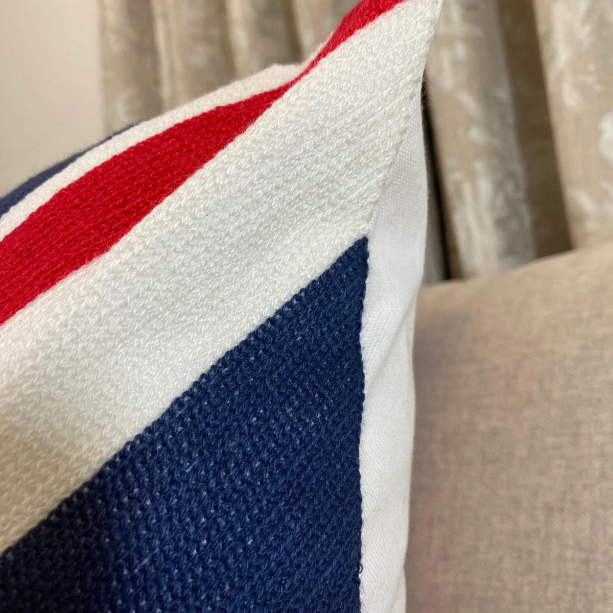 Union Jack cushion corner showing the dense embroidery and the plain cream back