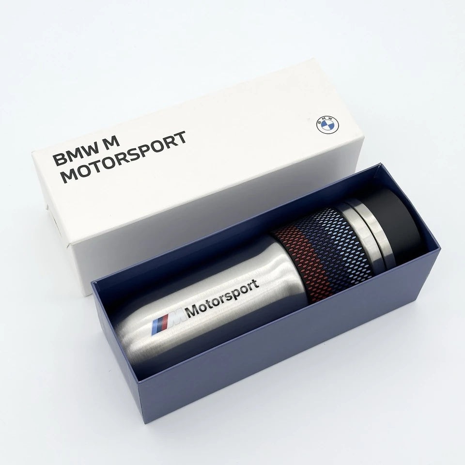 BMW M Motorsport insulated travel mug lying in its open white and navy BMW gift box