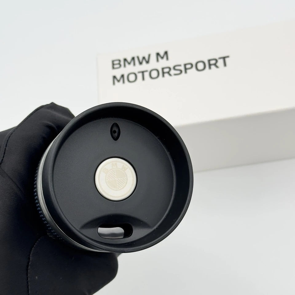 Push-button lid of the BMW thermos mug with the etched BMW emblem, sip opening and air vent