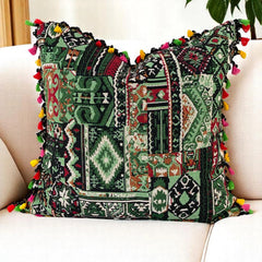 Boho kilim scatter cushion cover in deep green, black and burgundy with tassels on a cream sofa