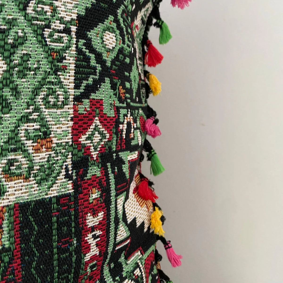 Close-up of the woven kilim patchwork cushion cover fabric and its multicolour tassel trim