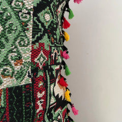 Close-up of the woven kilim patchwork cushion cover fabric and its multicolour tassel trim