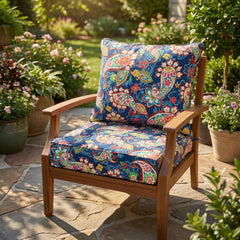 Navy paisley garden cushions on a teak armchair on a sunny stone patio