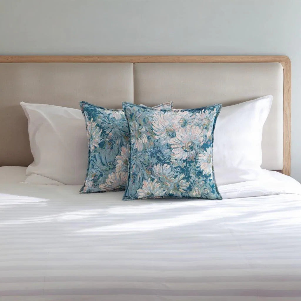 Floral tapestry cushion covers 50x50 cm on a white bed in front of a linen headboard