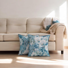 Teal vintage daisy scatter cushion covers propped against a cream sofa on a sunlit floor