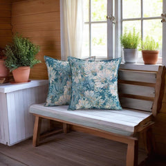 Blue and sage floral cushion covers on a wooden window bench in a cottage-style room