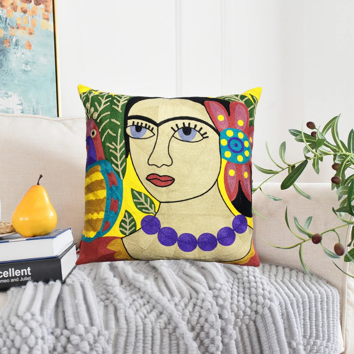 Frida-inspired embroidered cushion cover 50x50 cm on a cream sofa with a grey knitted throw