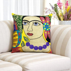 Colourful folk-art embroidered cushion cover with a portrait design on a striped cream sofa