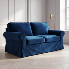 Blue velvet IKEA Ektorp slipcover on a 2 seater sofa in a panelled living room with a brass floor lamp