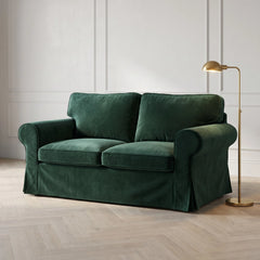 Bottle Green velvet IKEA Ektorp slipcover on a 2 seater sofa in a panelled living room with a brass floor lamp