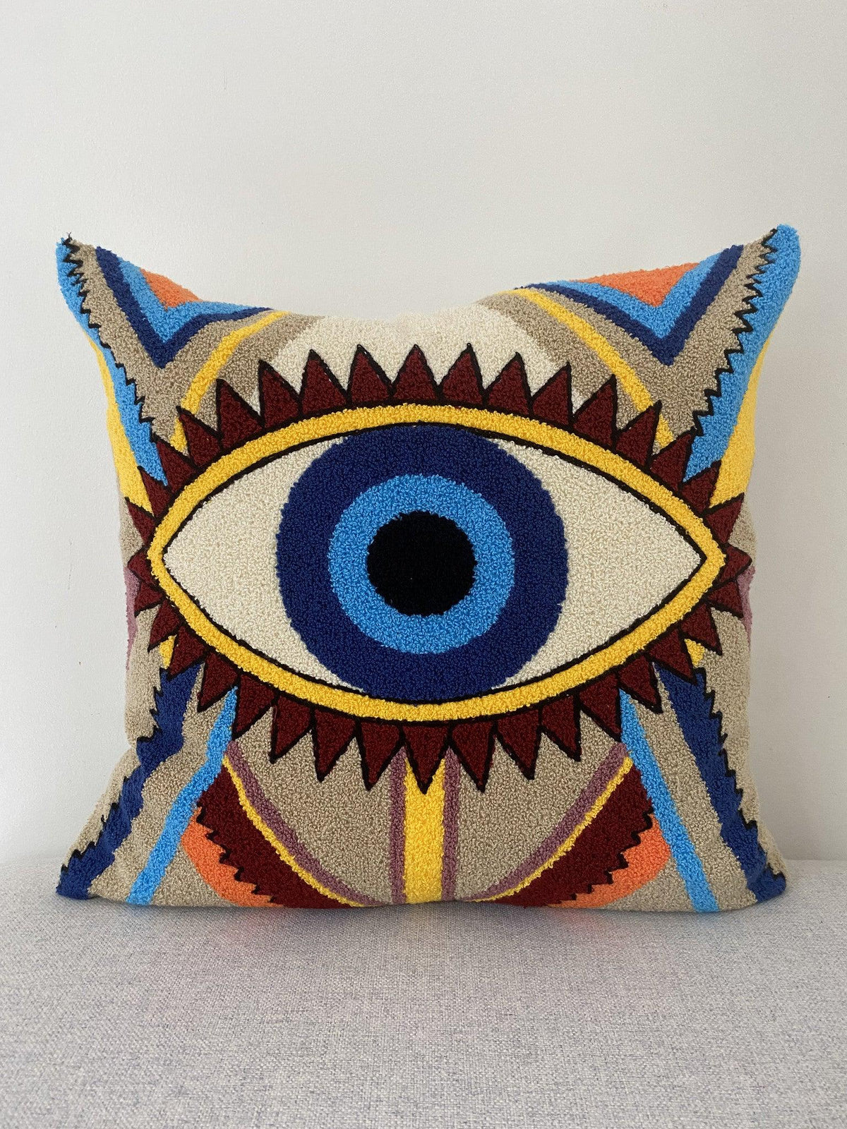 Evil eye cushion cover 50x50 cm with a tufted nazar design in blue, yellow and burgundy, front view