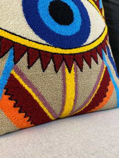 Detail of the tufted zigzag stripes in burgundy, orange, yellow and mauve on the cushion cover