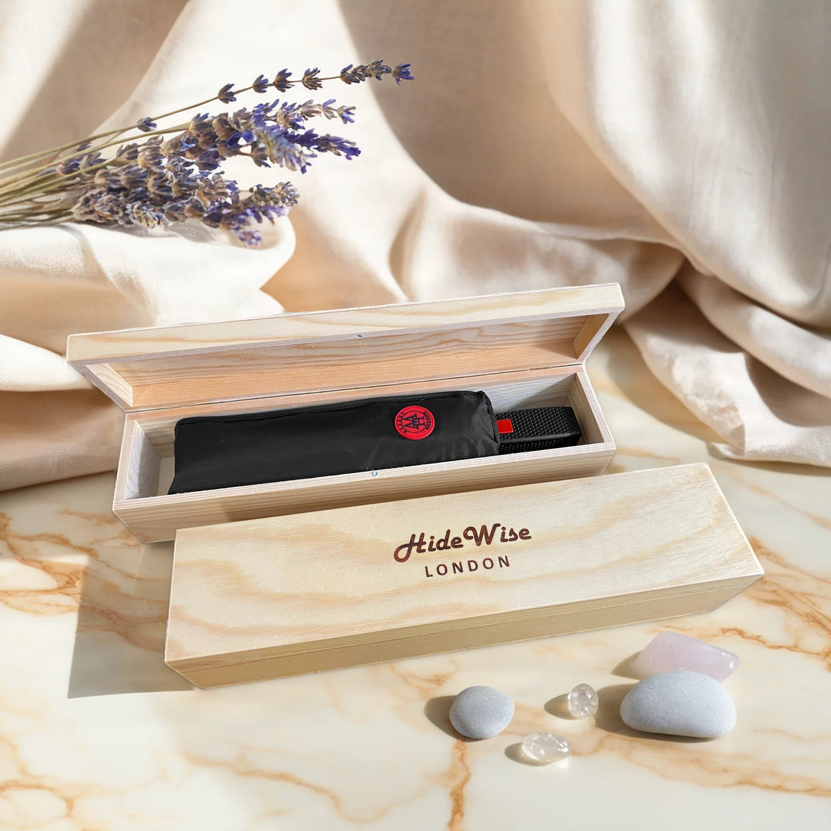 HideWise London black compact folding umbrella packed in an engraved pine wood gift box, on a marble table