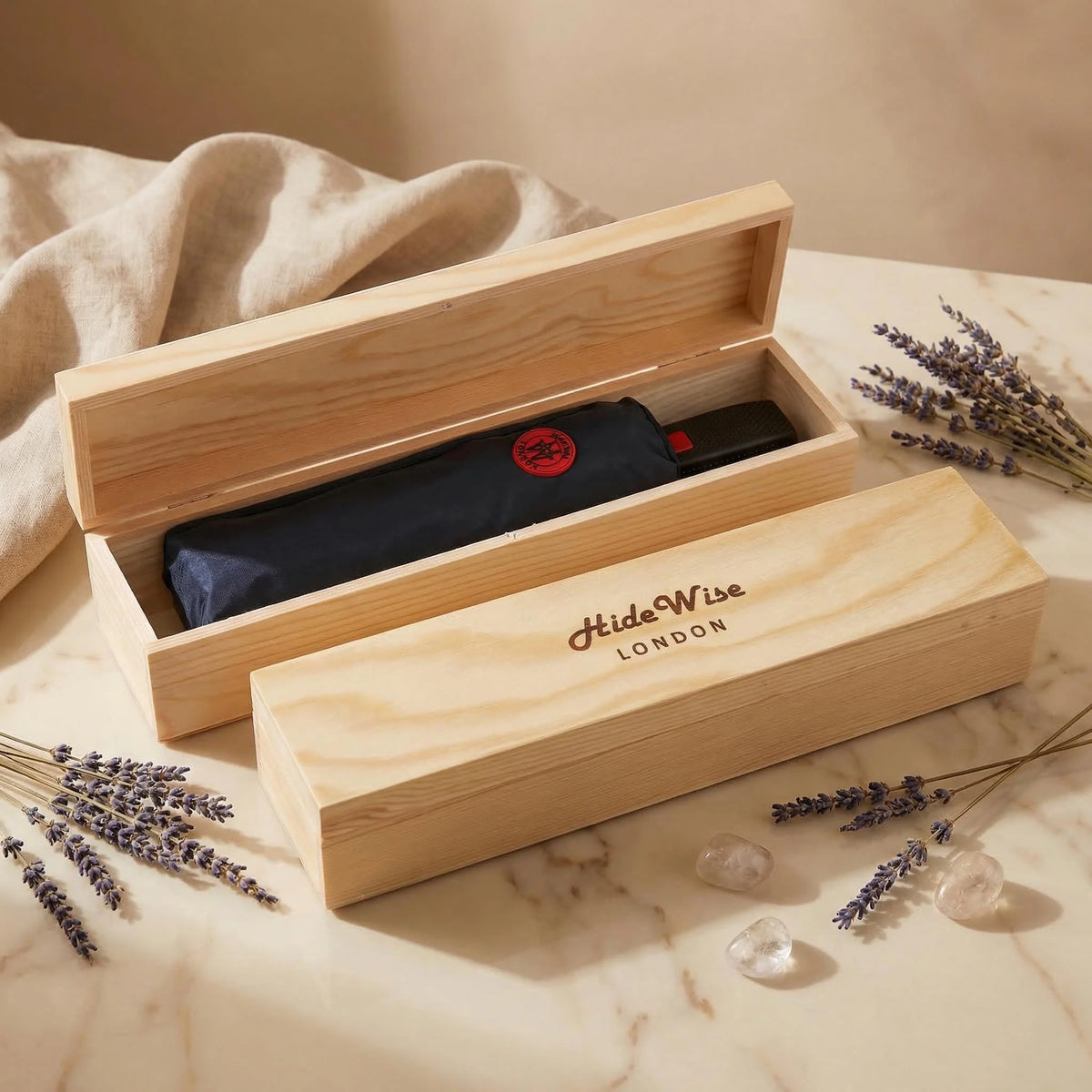 Pine wooden gift box open with the black compact folding umbrella packed inside, ready to give
