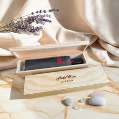 HideWise London graphite grey compact folding umbrella packed in an engraved pine wood gift box, on a marble table