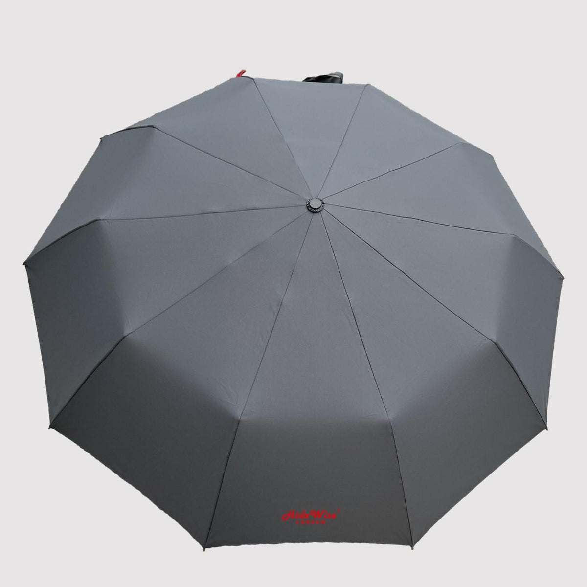 Grey compact umbrella from above, showing the 10-panel UV-resistant canopy and red HideWise London logo