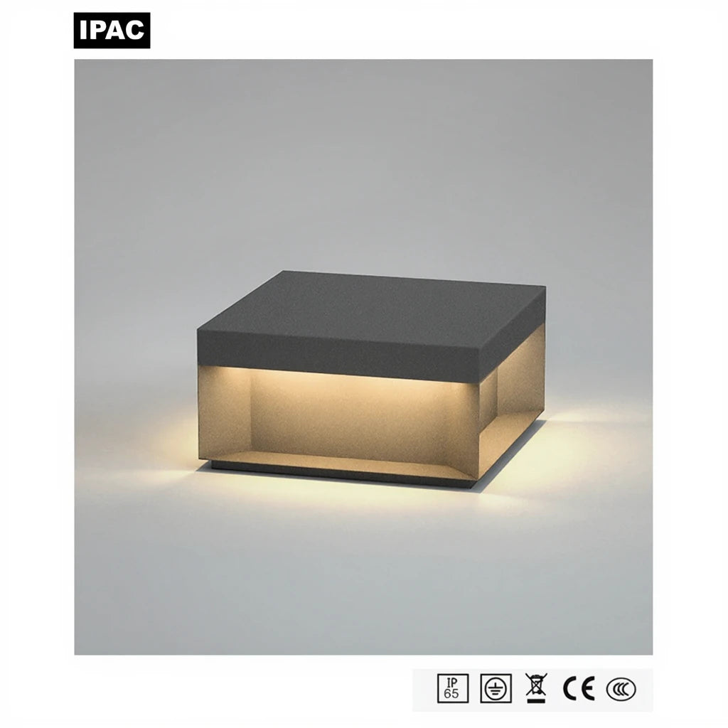 Square outdoor LED pillar light in anthracite grey, lit with a four-sided neutral white glow