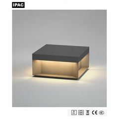 Square outdoor LED pillar light in anthracite grey, lit with a four-sided neutral white glow