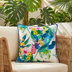Velvet floral scatter cushion cover on a rattan armchair in front of monstera plants