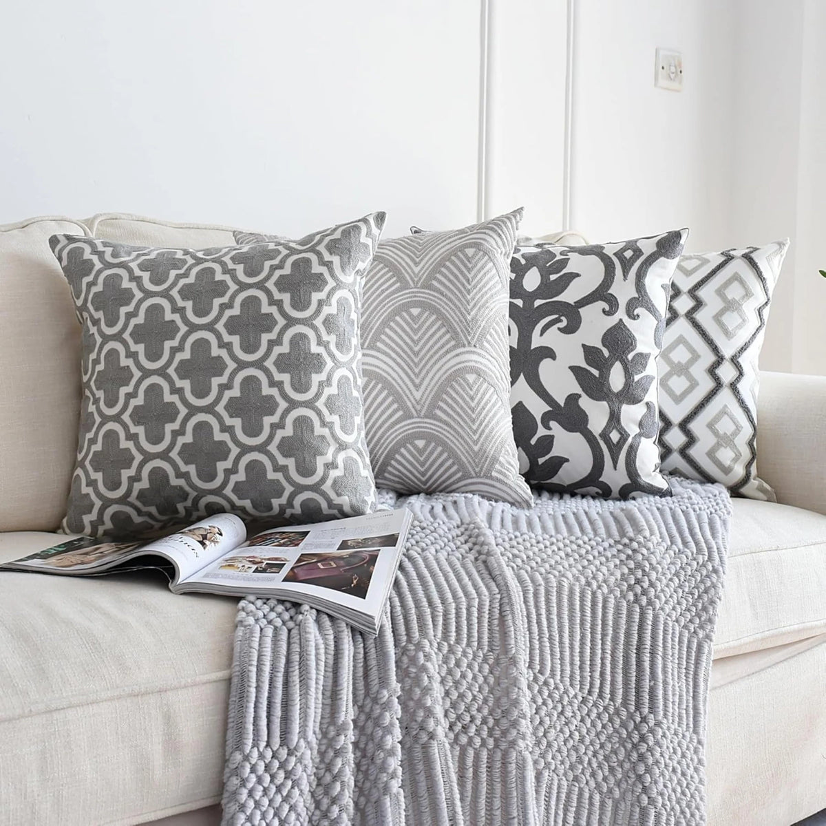 Embroidered cushion covers 50x50 cm set of 4: Moroccan trellis, Art Deco waves, baroque bloom and lattice on a cream sofa