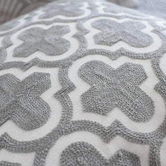Moroccan trellis embroidery in grey on white cotton, a detail of one 50x50 cm cushion cover in the set
