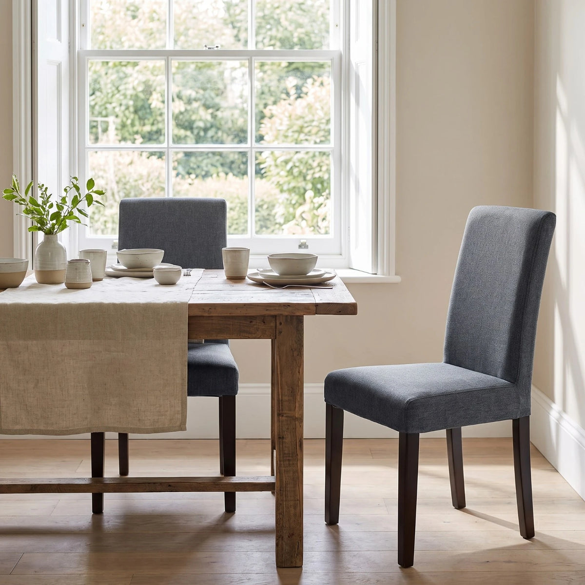 Two IKEA Bergmund chairs in grey replacement covers at a farmhouse dining table