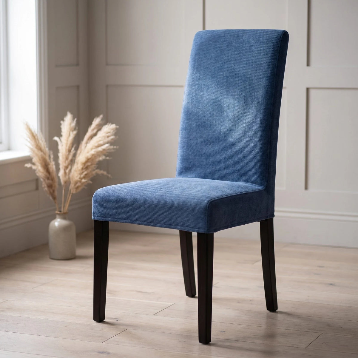 Blue Bergmund chair cover in soft polycotton on a dining chair in a panelled room