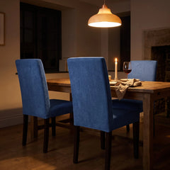 Denim blue dining chair covers on Bergmund chairs at a candlelit table