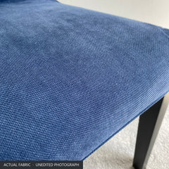 Close-up of the denim blue stretch-woven polycotton on the seat of the Bergmund chair cover