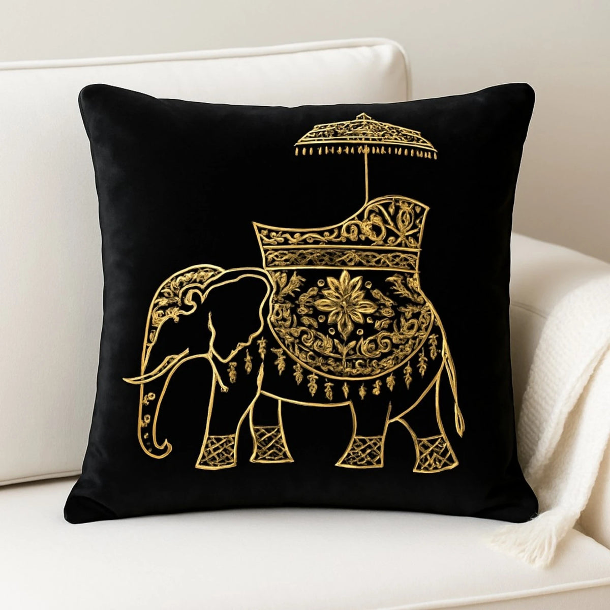 Black velvet cushion cover with gold embroidered elephant on a white sofa
